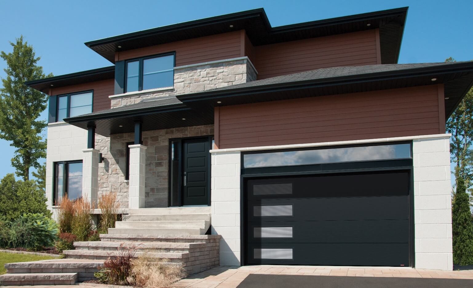 Brick house in shades of beige with brown vinyl siding and a square roof, paired with a Flush design double garage door in Black.