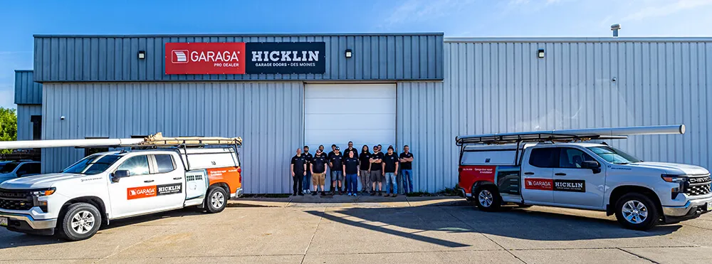 Garage door specialists team in from of Hiclkin Garage Door building with their service trucks