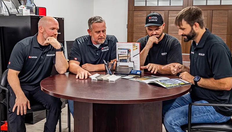 Garage door specialists sitting at a table looking at brochure and talking